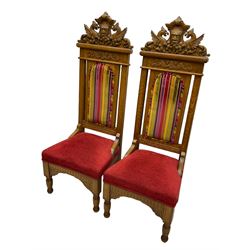 Set of six 20th century Carolean design oak high back chairs, the pediment carved with dragons and central Green Man mask with trailing foliage, the backs upholstered in striped fabric, on turned front supports