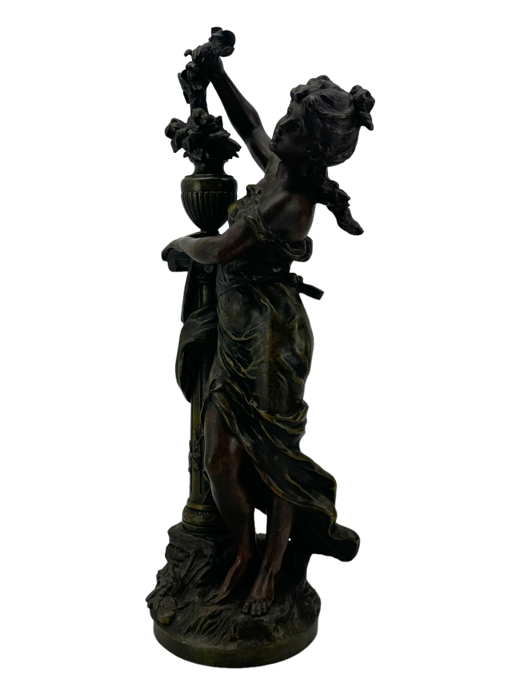 After L & F Moreau - Spelter table lamp in the form of a female figure next to a pedestal on circular naturalistic base H55cm