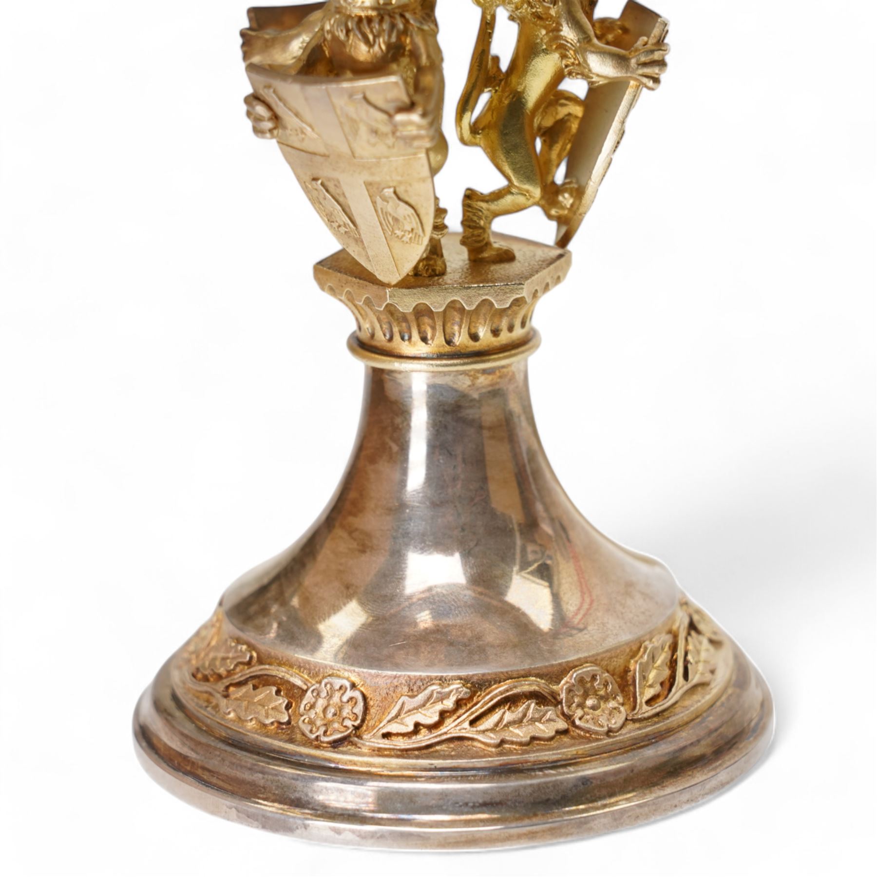 'The Herald's Tazza' limited edition silver ornamental cup, designed by Hector Miller and Tim Minett for Aurum, the sculptured gilt stem comprising three heraldic lions each bearing a coat of arms, decorated to the foot and bowl with gilt borders of repeating oak leaves and Tudor roses, no. 21/250, hallmarked Hector Miller, London 1985, H15cm, with certificate 