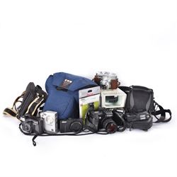 Collection of cameras and camera equipment, including Voigtlander Vitomatic I, Nikon Coolpix P340, Nikon Coolpix S9100, Olympus SP-510UZ, tripod, cases, etc