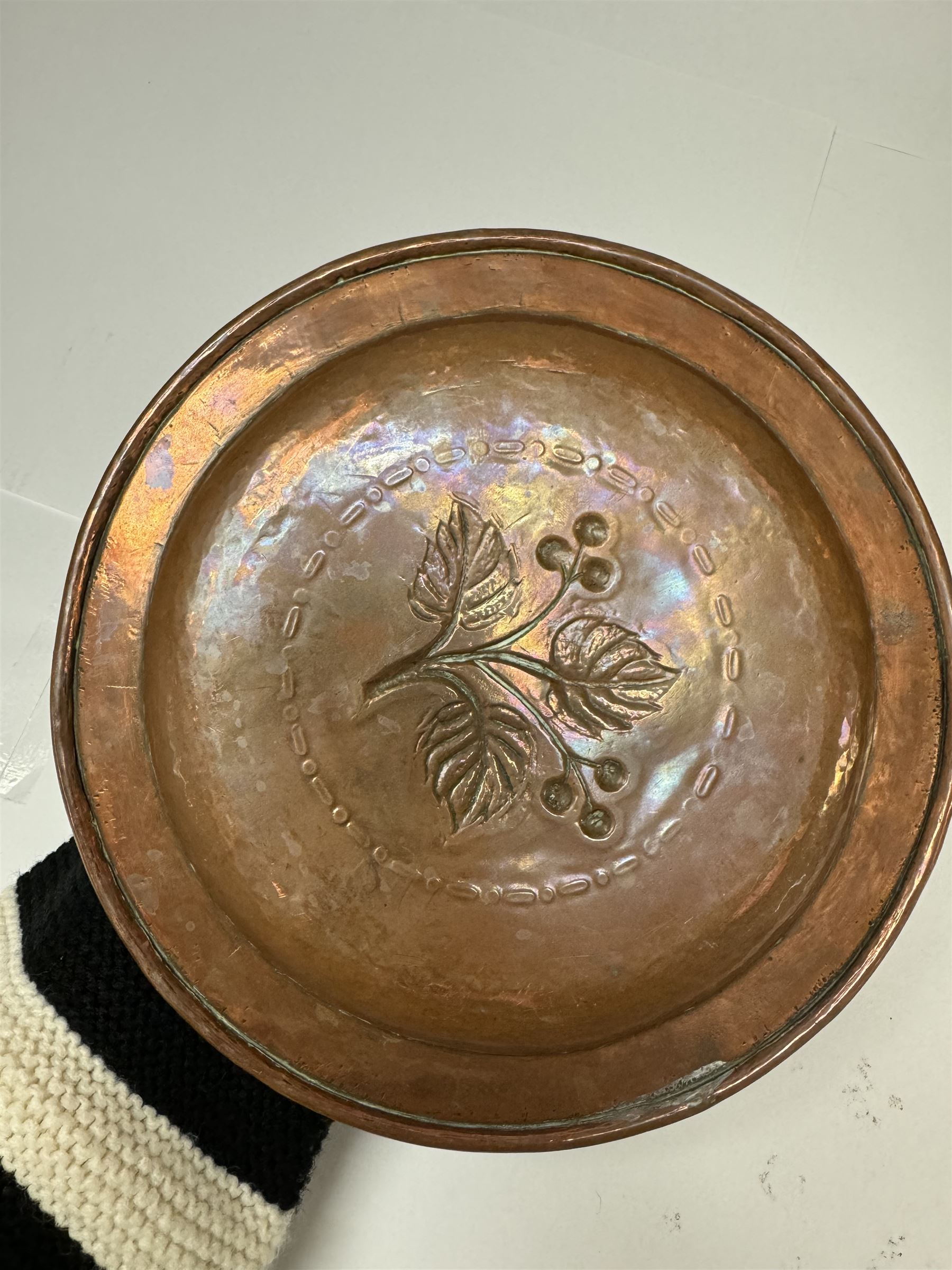 Middle eastern copper bucket, with chased and embossed band of animal decoration, together with a copper jardinière embossed with floral panels, copper plate with embossed leaf motif and two brass helmet shaped coal scuttles, bucket H26cm