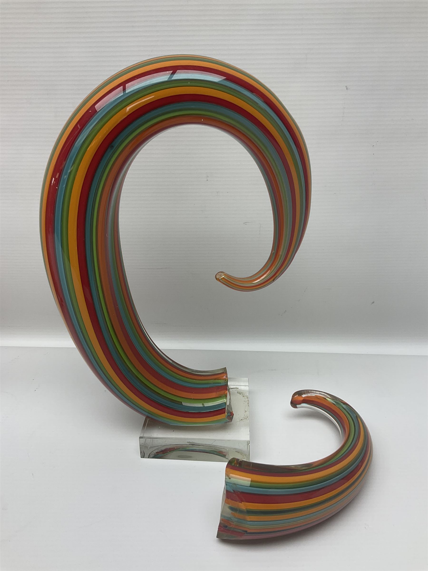 Three art glass sculpture, coiled form with multicolour stranded, upon clear glass plinth, unsigned, largest H27cm