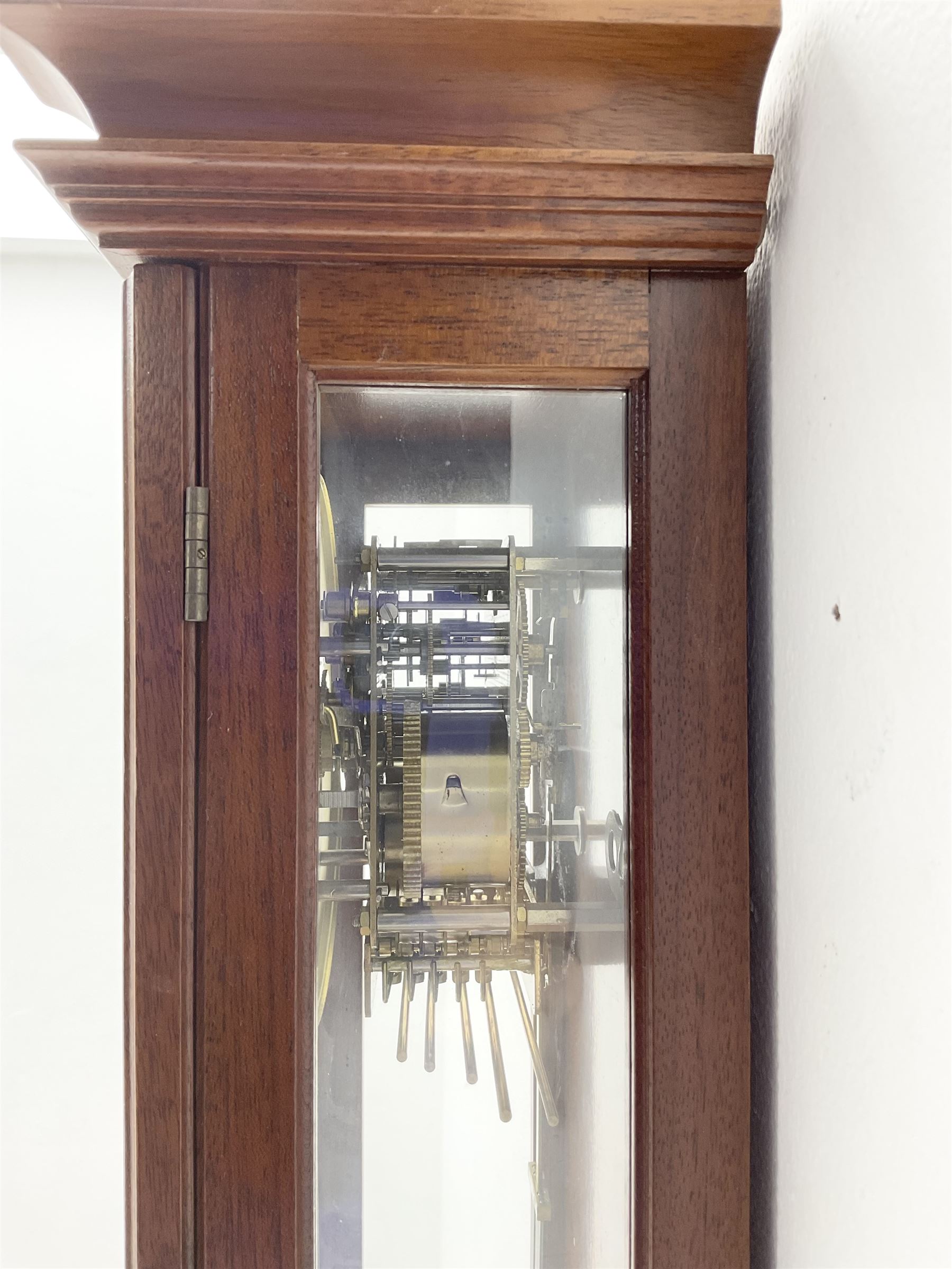 Comitti,  London - 20th century 8-day chiming wall clock in a walnut case, with a moulded break-arch top and full length glazed door and side panels, two part enamel dial with spade hands and visible gridiron pendulum, three train spring driven movement chiming the quarters on 5 gong rods.