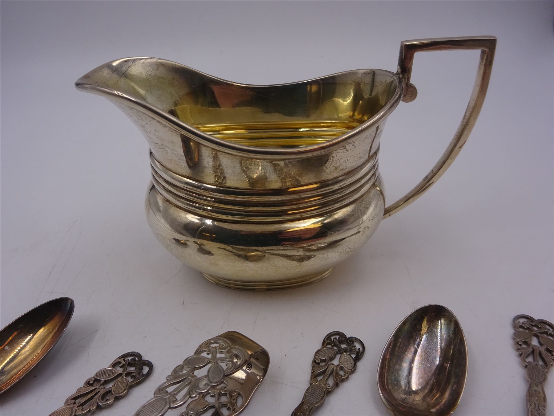 Early 20th century silver jug, of oval slightly bellied form, with angular handle and banded decoration to body, hallmarked Fordham & Faulkner, Sheffield 1911, together with set of five 1920s silver tennis themed coffee spoons and sugar tongs, hallmarked  Josiah Williams & Co (David Landsborough Fullerton), London 1922, jug H9cm