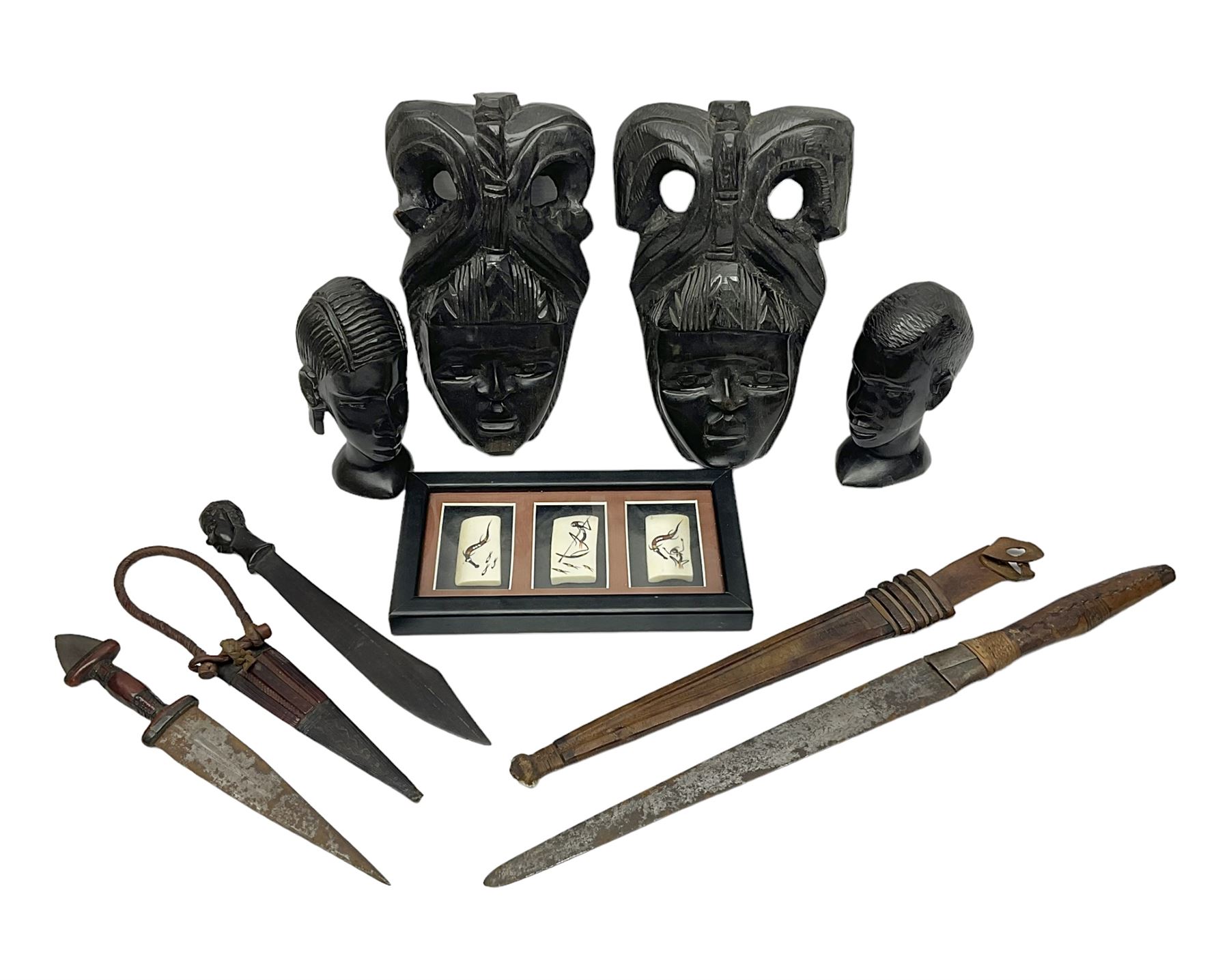 Two African tribal daggers, four carved masks/busts and similar collectables