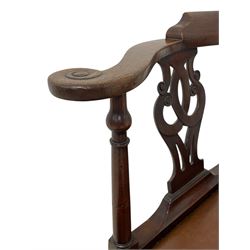 George III mahogany corner elbow chair, curved back rest and shaped arms with scroll carved terminals, on turned supports and pierced scroll carved interlaced splats, drop-in seat upholstered in brown leather, on square supports with inner chamfer and outer moulding 