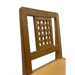 Mouseman - set of six oak dining chairs, pierced and carved lattice panel back over tan leather seat with studded band, on octagonal front supports united by plain H stretchers, carved with mouse signature, by the workshop of Robert Thompson, Kilburn 