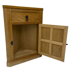 Mouseman - oak floor standing corner cupboard, fall front compartment over single panelled door, with wrought metal loop handle and latch, on moulded plinth base, carved in relief with mouse signature, by the workshop of Robert Thompson, Kilburn 