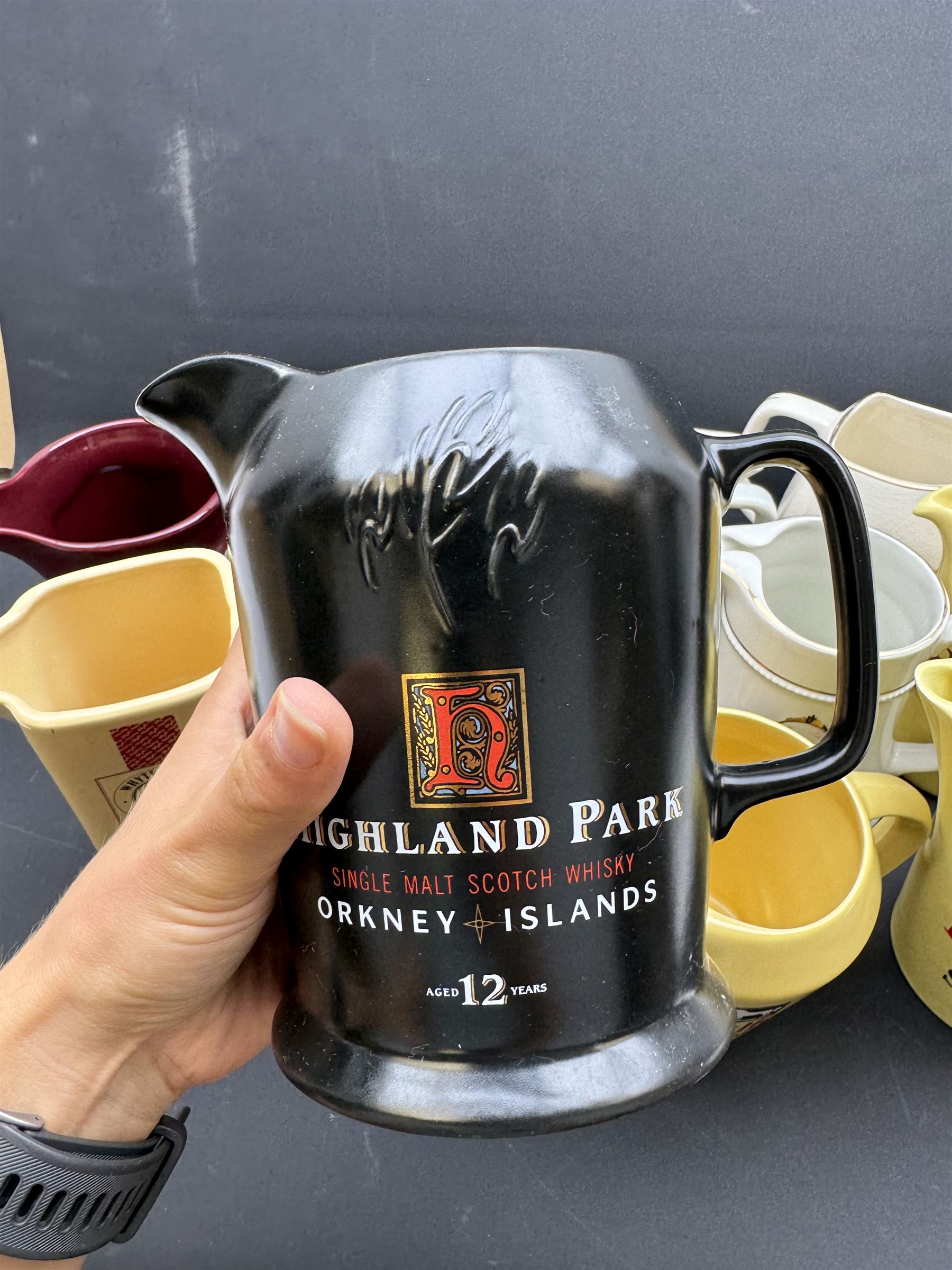 Eighteen ceramic whisky jugs bearing various advertising, including Cutty Sark, White Horse, Bells, Langs Supreme etc 