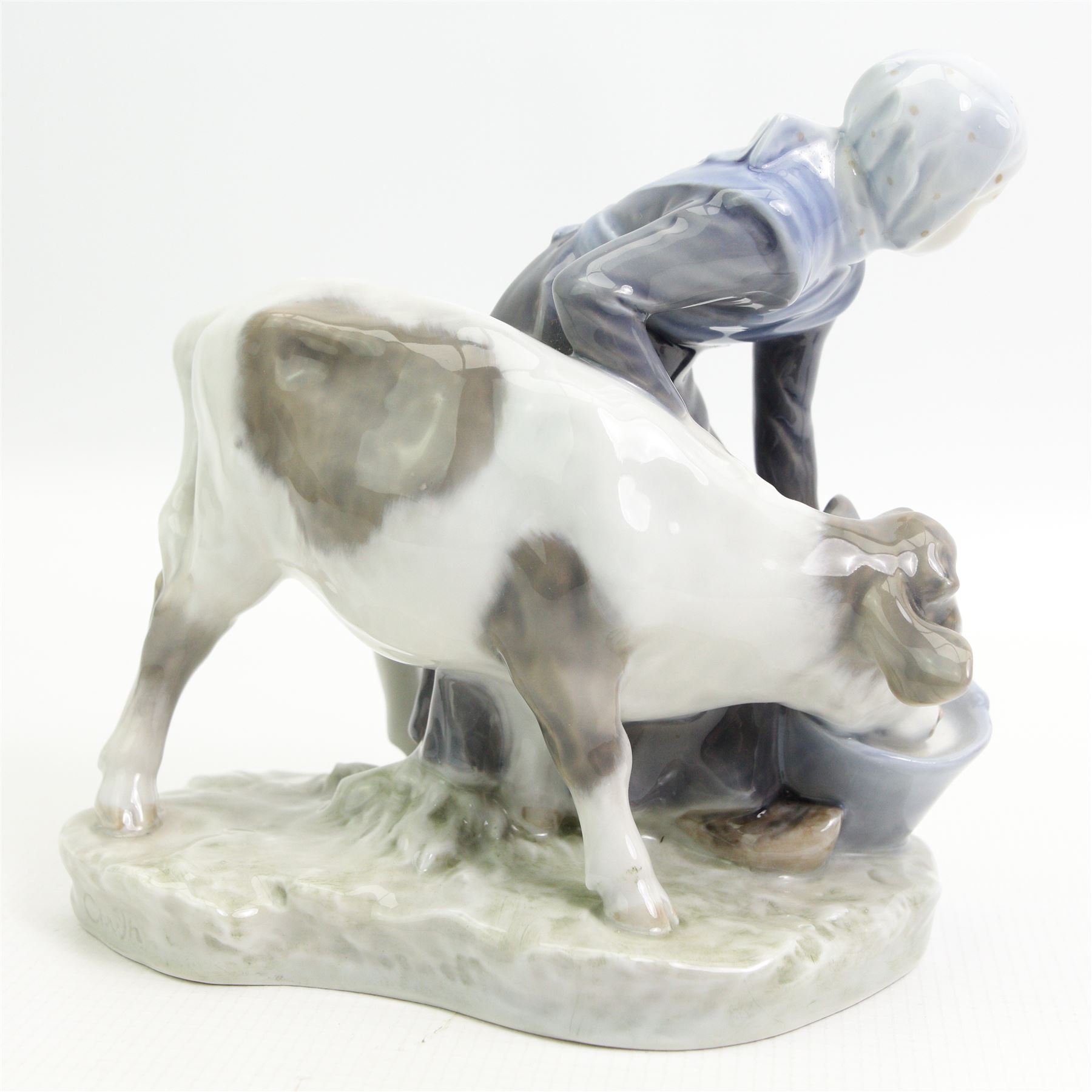 Royal Copenhagen figure of a girl feeding a calf No.799 H16cm, Copenhagen cobalt blue vase decorated with crocus H12cm, Copenhagen penguin No.3003 and a Bing & Grondahl pig