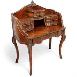 Early 20th century Louis XV design Kingwood and ormolu mounted bonheur du jour, shaped raised back fitted with five drawers and central recess, surmounted by scrolling foliate casting and pierced gallery, single frieze drawer with sliding top inset with crushed velvet, on cabriole supports mounted by mask castings with extending floral decoration, the sides and drawer fronts inlaid with parquetry panels 