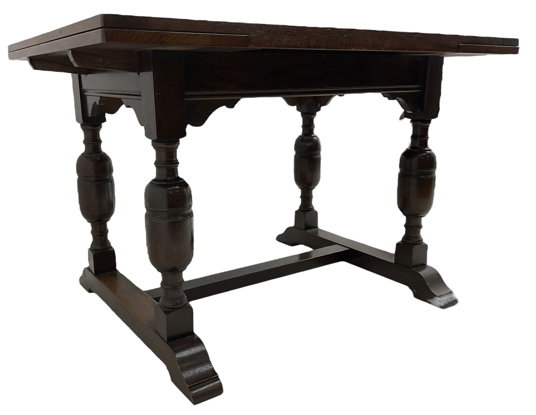 Mid-20th century medium oak dining table, rectangular draw-leaf extending top, quadruple turned pillar supports on sledge feet joined by stretcher