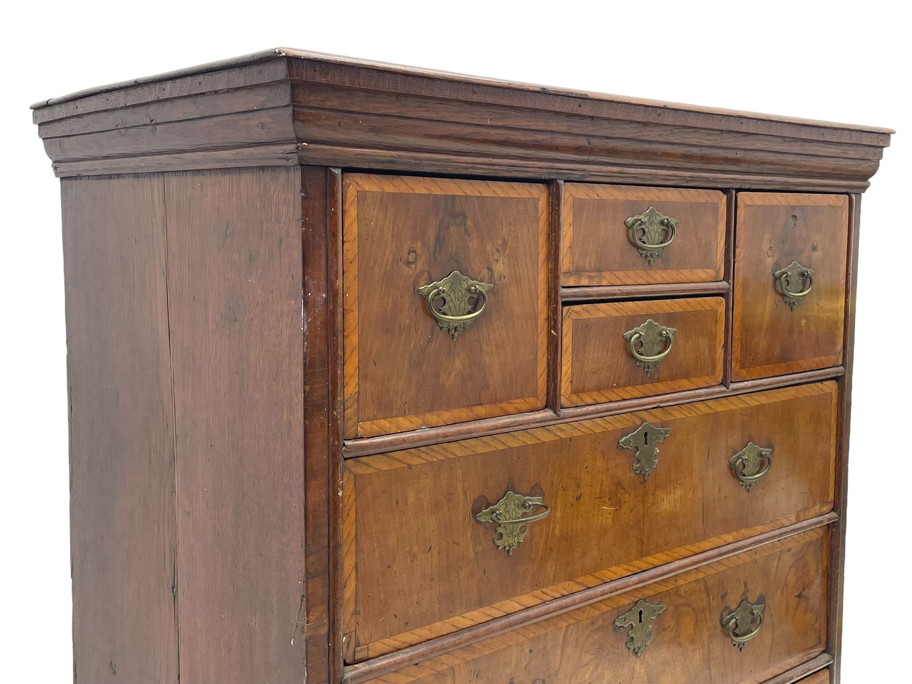 18th century oak and walnut chest, fitted with four small over three long drawers with figured walnut facias, brass handles and plates with engraved decoration, on bracket feet