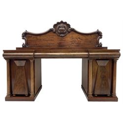 Victorian mahogany reverse break-front sideboard, raised shaped back with central carved shell cartouche and extending foliage decoration, fitted with three drawers over two cupboards, enclosed by two doors with applied faceted mounts and turned columns, on plinth base 