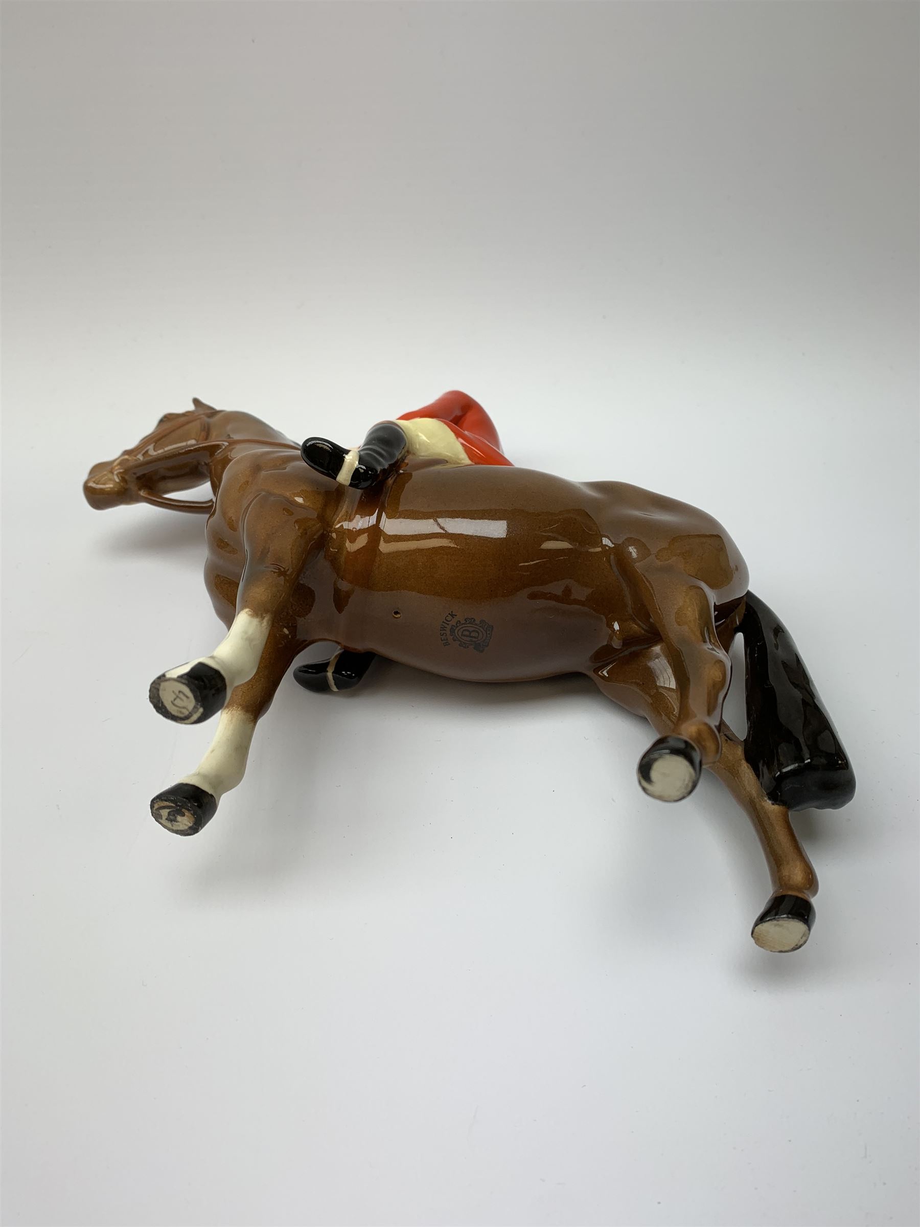 A Beswick equestrian figure modelled as a huntsman on bay horse, with printed mark beneath, together with a Beswick Norman Thelwell figure of a pony and rider, with printed mark beneath  