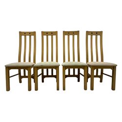 Contemporary set of four oak dining chairs, tall slatted curved backs with square cutouts to the top, upholstered seats in light fabric, on square front supports