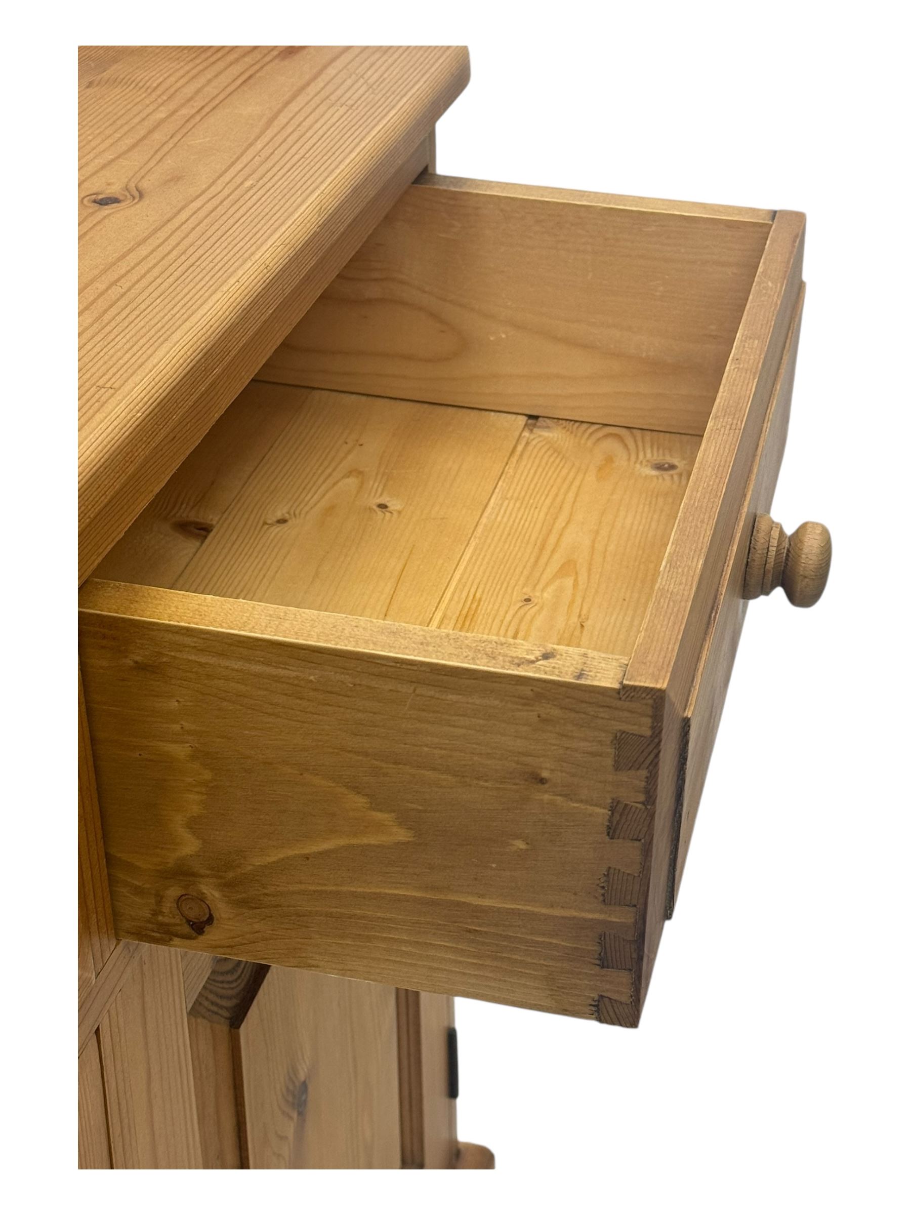 Large traditional pine dresser, shaped cornice over three open shelves, base fitted with four drawers above four panelled cupboards, each with turned wooden knobs, on plinth base