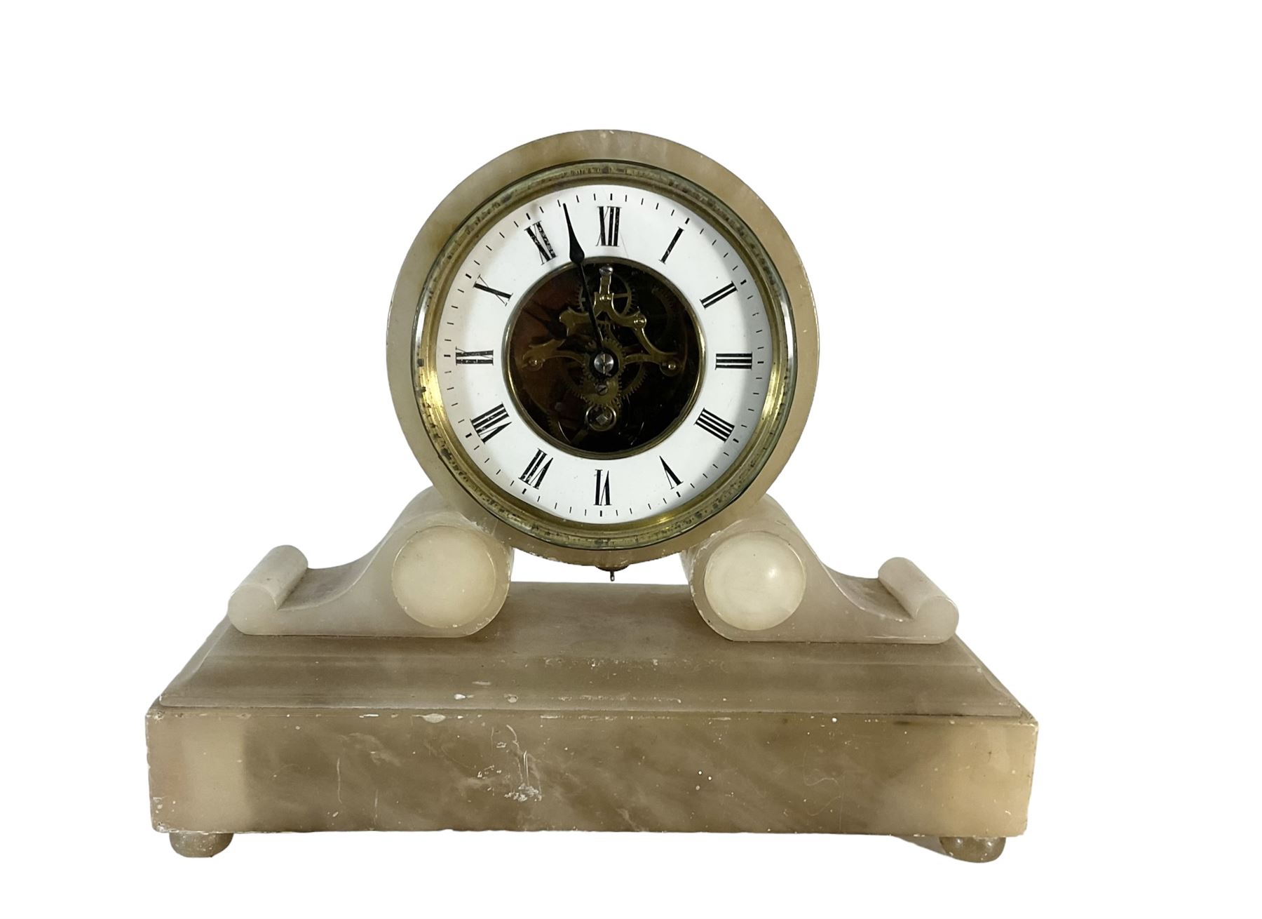 French - late 19th century 8-day mantle clock in an alabaster case,  with a drum movement raised on scroll supports and stepped plinth, open dial displaying the skeleton movement, escapement and motion work, enamel chapter with Roman numerals and spade hands enclosed within a glazed brass bezel, single train tick tac escapement with integral pendulum, wound and set from the front.