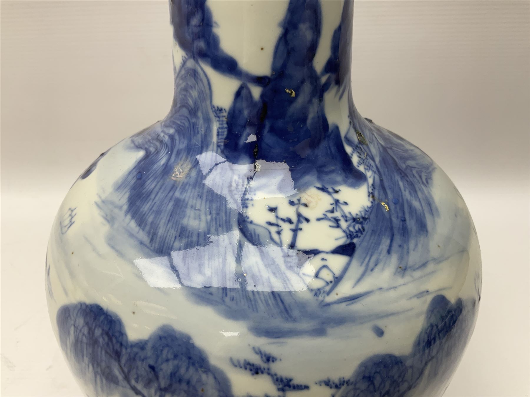 Late 18th/early 19th century Chinese blue and white bottle vase, decorated with a landscape scene containing dwellings, prunus and pine trees, boats and bridges, and populated with figures, with character mark beneath, H35cm