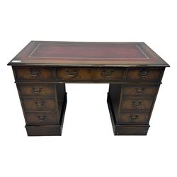 20th century mahogany twin pedestal desk, moulded rectangular top with red leather inset with gilt tooled border, central drawer over kneehole flanked by two banks of four graduating cockbeaded drawers, on plinth base