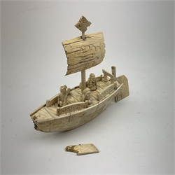 A Japanese carved ivory model of a sailing boat, surmounted by three carved figures (a/f), L22.5cm, together with a smaller sail boat with malachite hull and ivory sails and rudder, H18cm. 