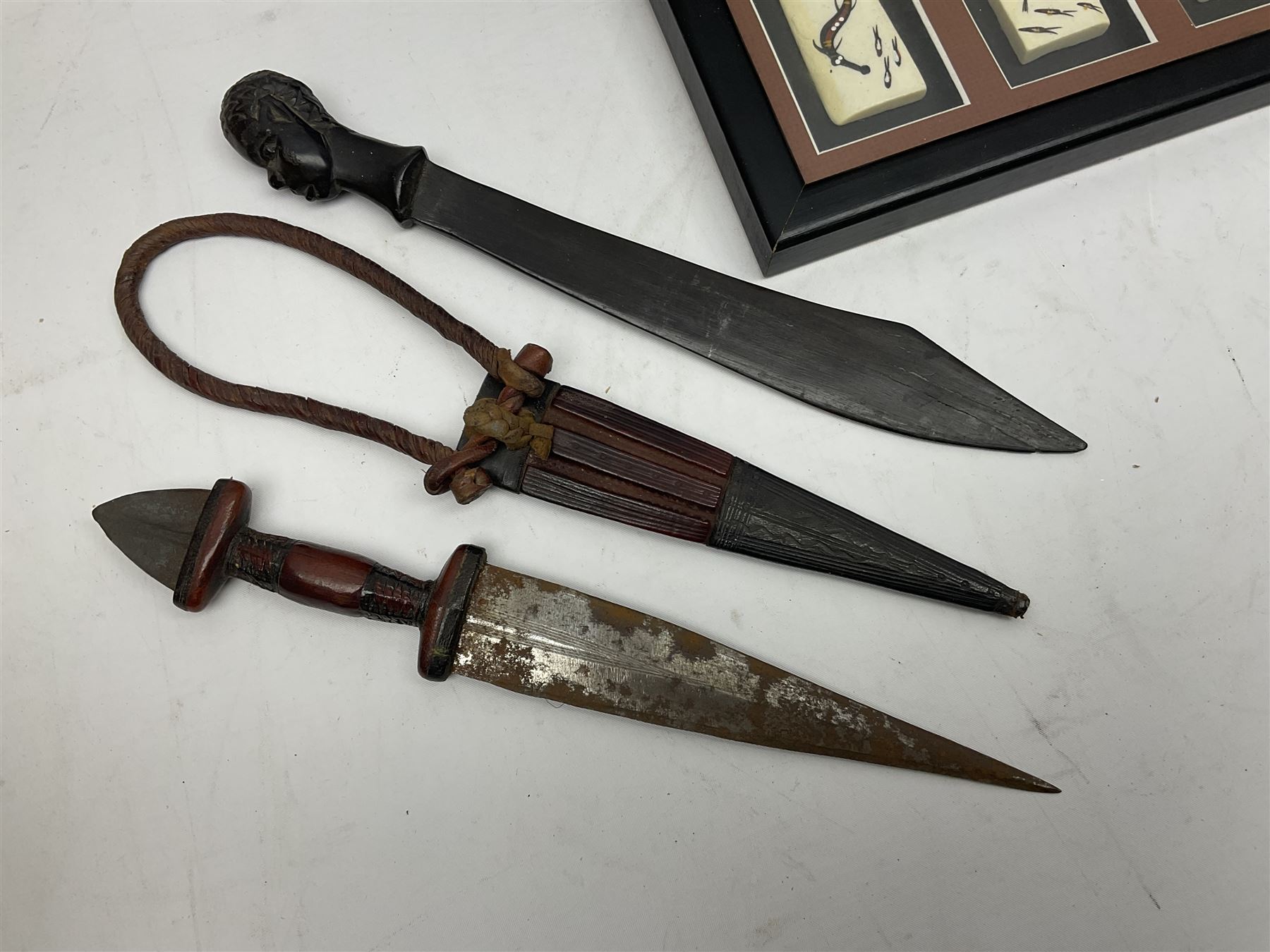 Two African tribal daggers, four carved masks/busts and similar collectables