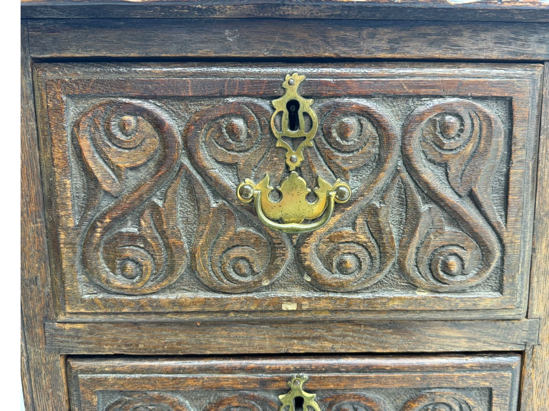 Victorian carved oak kneehole desk, the rectangular top with carved edge, above central drawer with carved front and brass handles, central kneehole with cupboard door, flanked by two banks of three graduating drawers each with similarly carved decoration, on shaped plinth base with castors