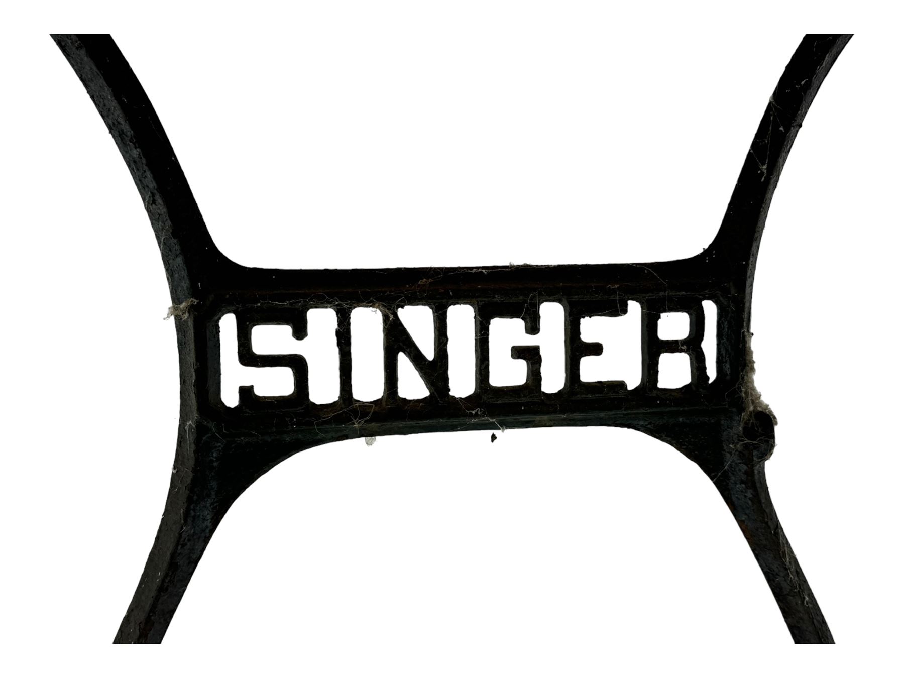 Late 19th century Singer sewing table, rectangular mahogany top mounted on a black cast iron base with decorative scrollwork and 'Singer' logo, on curved supports 