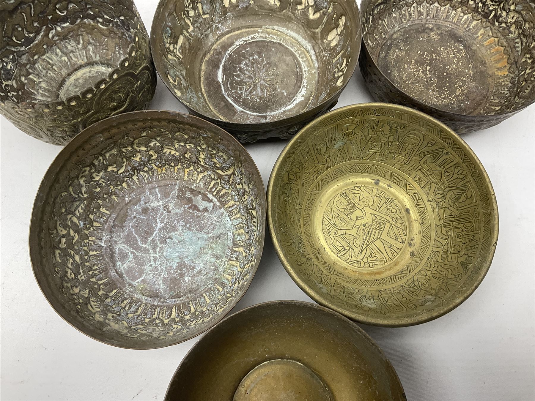 Beaten copper tray with repeat pattern and fluted rim, together with six brass cups, tray L41cm 