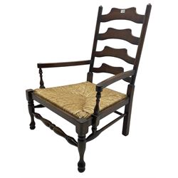 Georgian design oak country low armchair, waived ladder back over rush seat, raised on turned  supports united by stretchers; together with matching stool