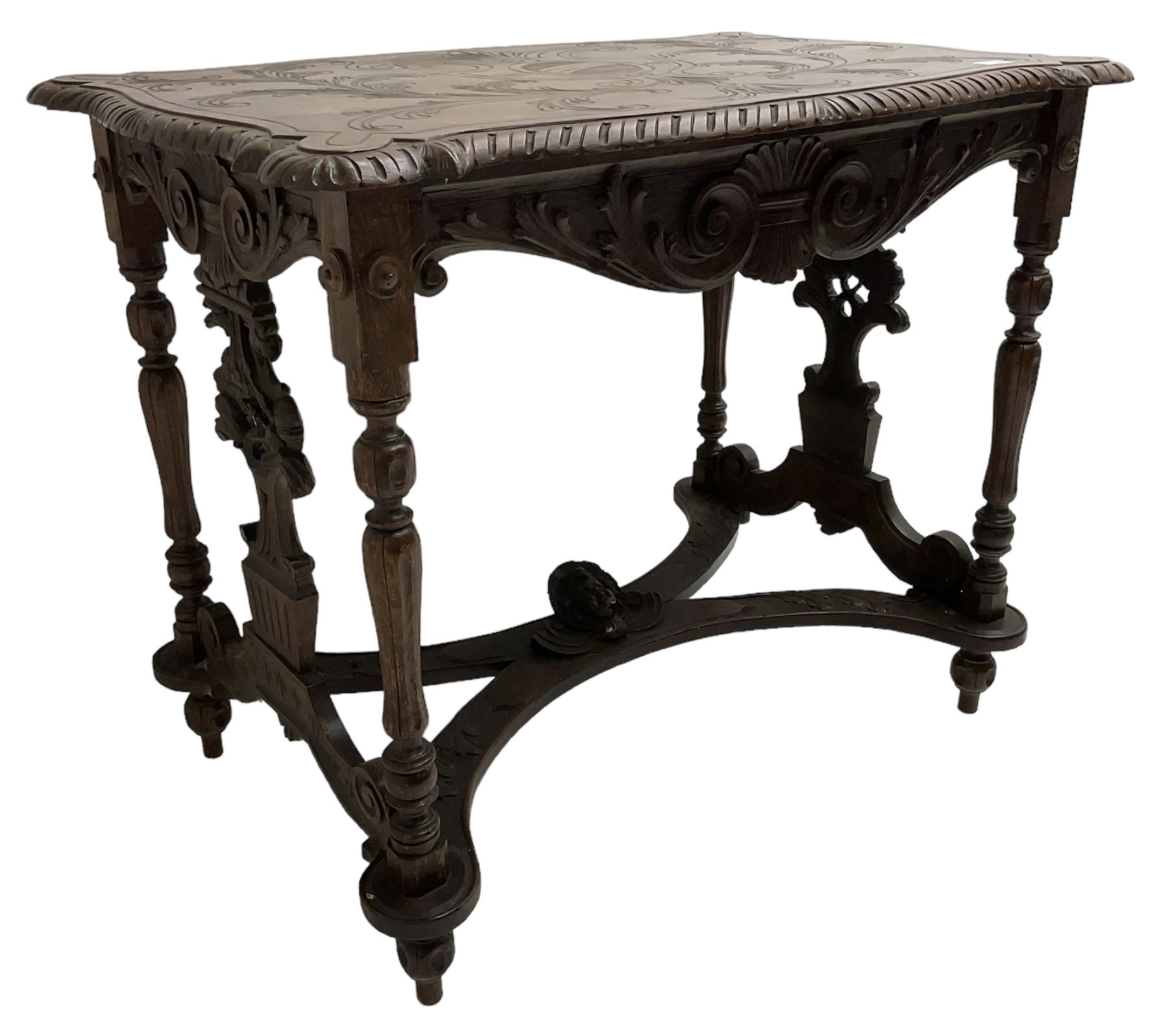 19th century walnut centre table, shaped top carved with central cartouche and extending scrolled foliage, the shaped frieze rails carved with scrolling acanthus leaves, turned supports with central end supports carved with flower heads and scrolls, curved x-framed stretcher carved with a central mask depicting a girl in a bonnet, on turned and carved feet