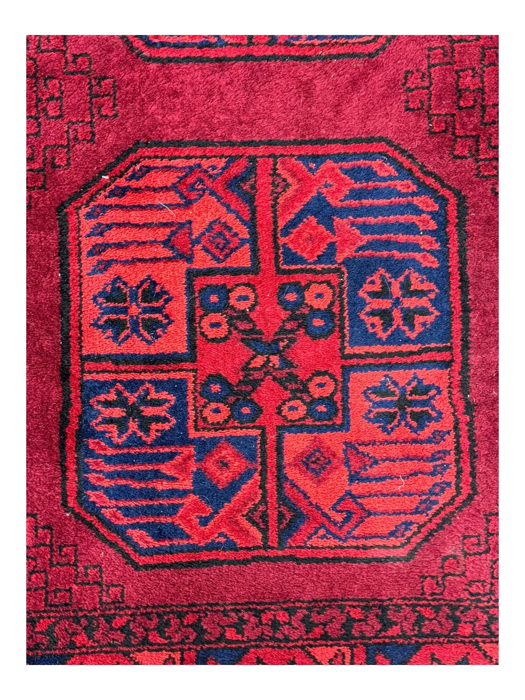 Persian Qashqai crimson ground rug, the field with central indigo and yellow medallion with geometric motifs, flanked by smaller medallions, border with repeating patterns (112cm x 200cm); Turkish Kazak light blue ground rug (109cm x 193cm); red ground runner with three octagonal medallions (69cm x 138cm)