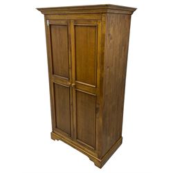 Hardwood double wardrobe, enclosed by two panelled doors, on bracket feet 