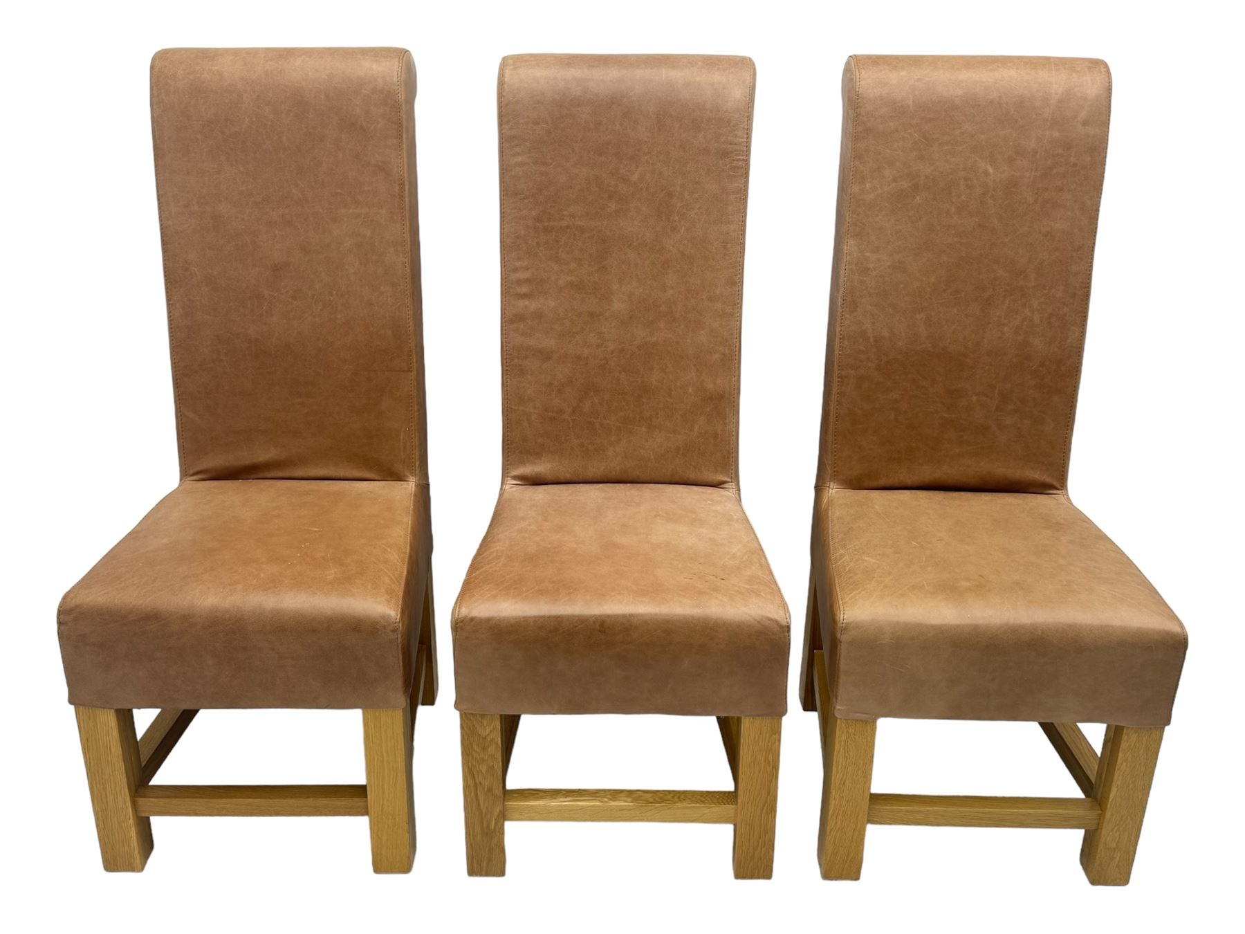 Set of six contemporary light oak dining chairs, each with high back and seat upholstered in pale tan leather, on square supports connected by H-stretcher