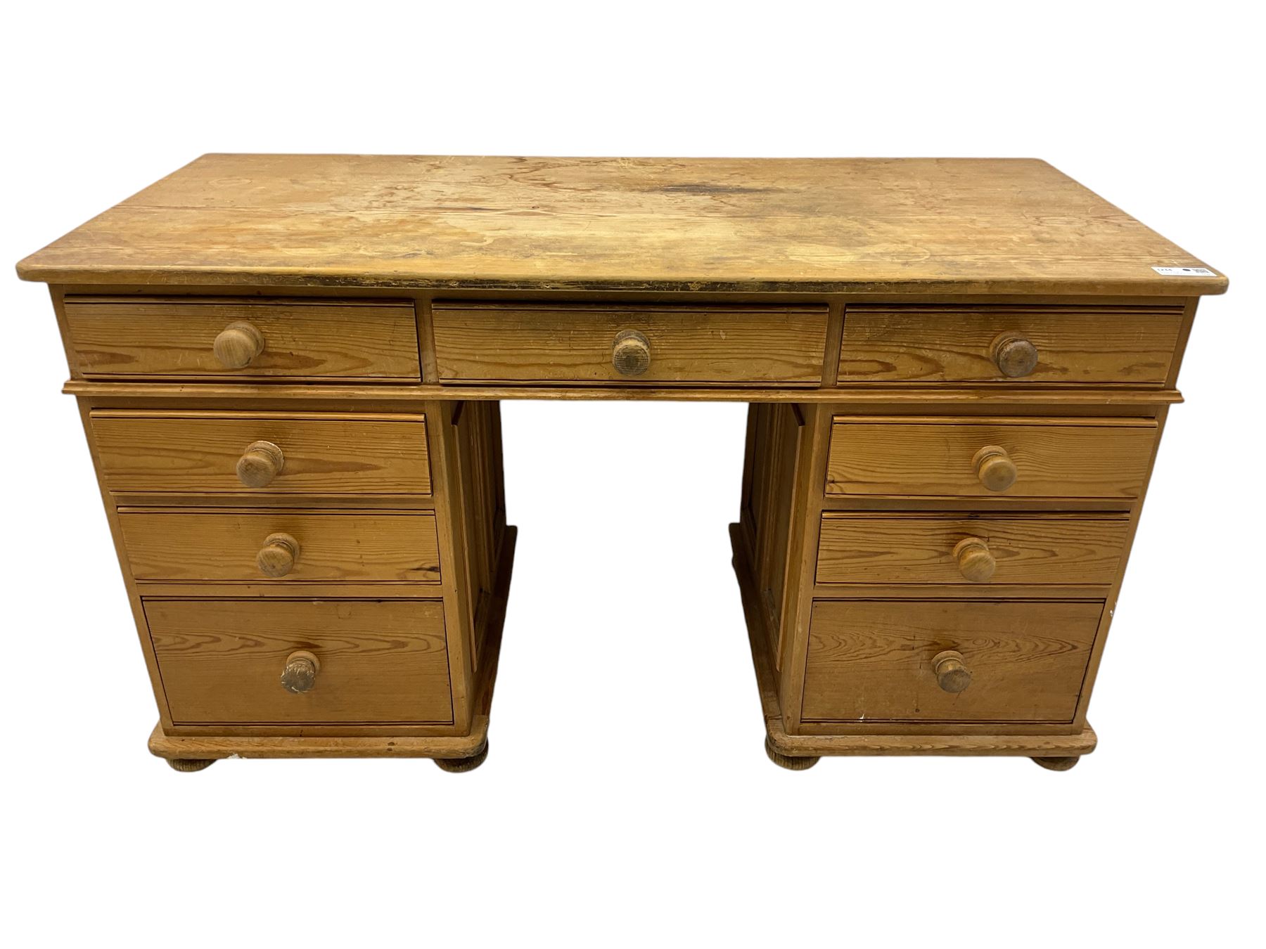 Waxed pine twin pedestal desk, rectangular top over nine drawers, on compressed bun feet 