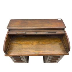 Early 20th century oak twin pedestal roll top desk, tambour roll enclosing fitted interior, each pedestal fitted with four drawers and slide, on plinth base 