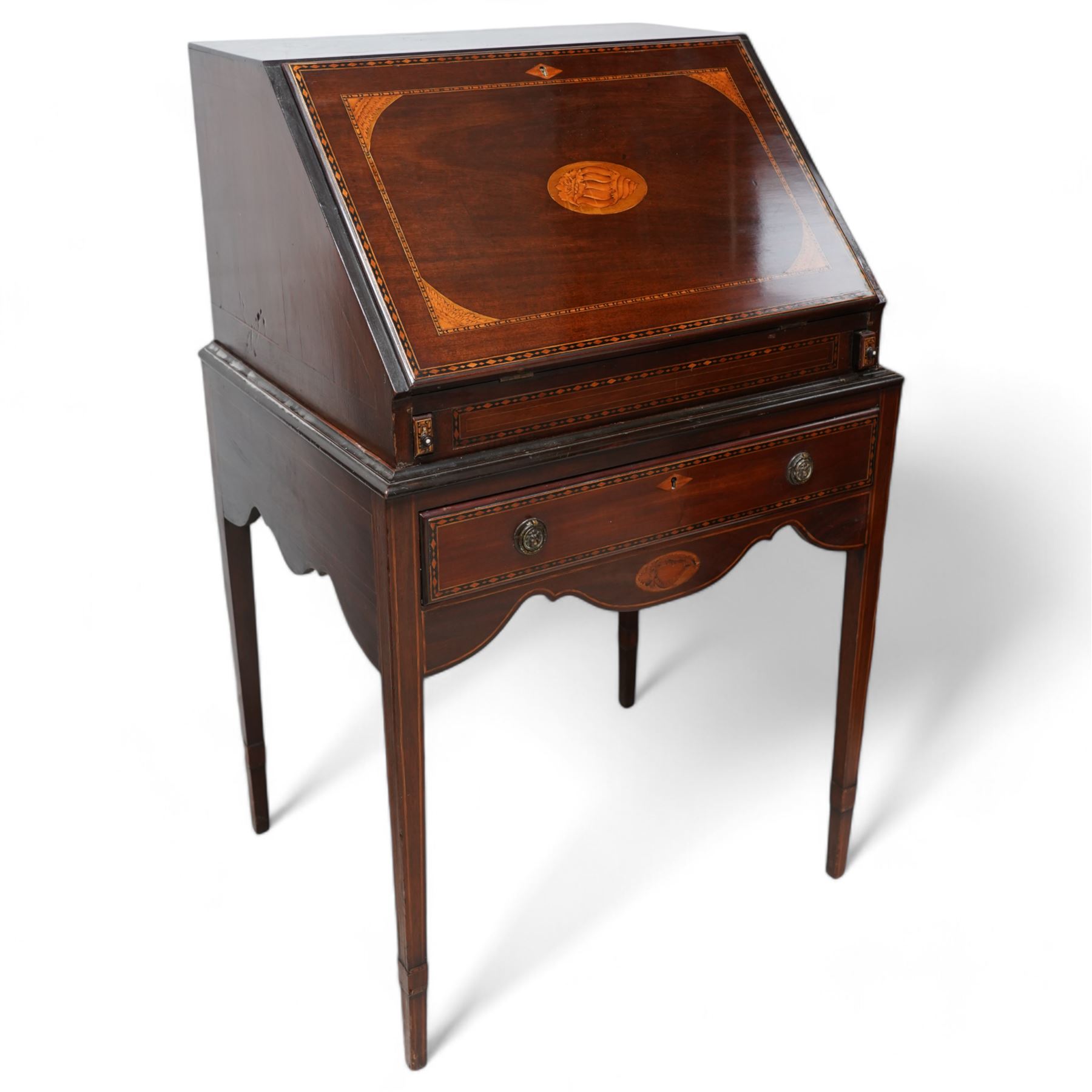 19th century inlaid mahogany bureau on stand, sloped moulded lid inlaid with shell motifs and parquetry bands, the interior fitted with drawers, small cupboard and document divisions, inlaid with soldier holding sword and shield flanked by classical columns, the stand fitted with single drawer over shaped apron inlaid with shell, on square tapering supports  