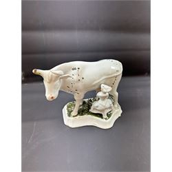 19th century Delft figure group depicting a milkmaid milking a cow, H17.7cm