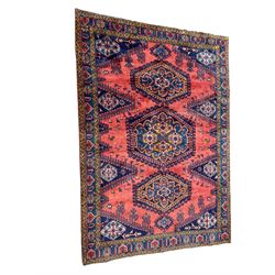 Persian Wiss pale crimson ground rug, three medallions with hooked borders, the field punctured with projecting lozenges, decorated with hac motifs, plain field decorated with stylised bird motifs, the border decorated with rosettes and repeating geometric motifs, within guard stripes 