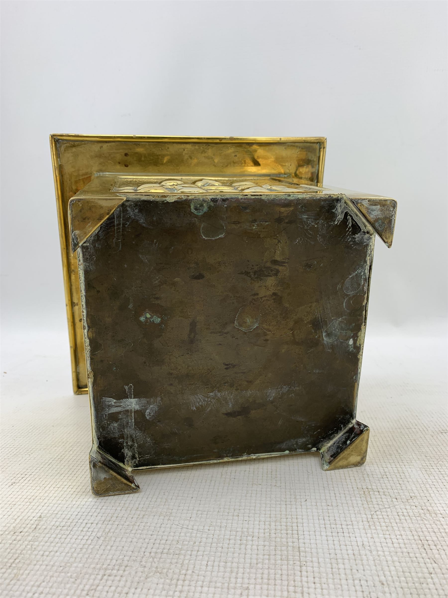 Arts and Crafts square brass planter, probably Glasgow School, with a raised pattern of stylised trees and foliage 23cm x 19cm and pair of brass candlesticks H25cm (3)