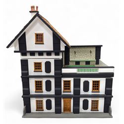 1:24 scale four-storey tudor-style dolls house, with black and white exterior, balcony gar...