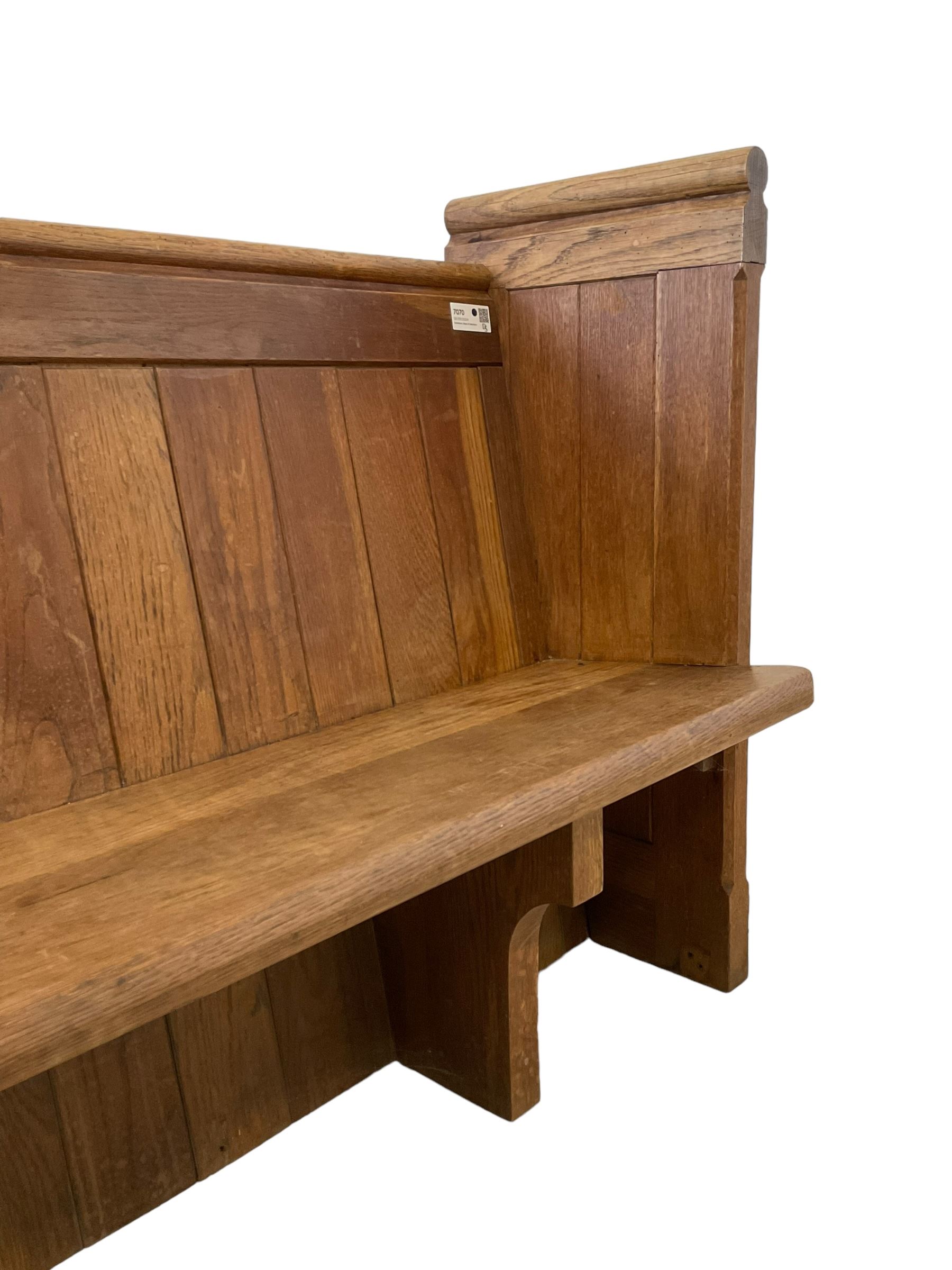 19th century oak church pew or hall bench, moulded cresting rail over panelled back and plank seat, on panelled end supports with chamfered frames