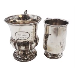 Two silver christening mugs, the first a Victorian example, of part fluted waisted form, upon circular foot with scroll handle, hallmarked Edward, John & William Barnard, London 1838, the second example of plain slightly tapering form with C handle, hallmarked S Blanckensee & Son Ltd, Chester 1929, tallest H9cm