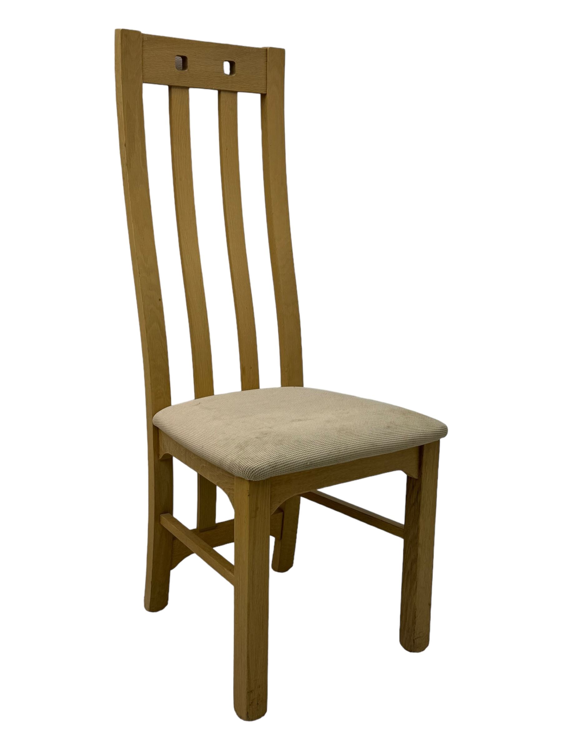 Contemporary set of four oak dining chairs, tall slatted curved backs with square cutouts to the top, upholstered seats in light fabric, on square front supports