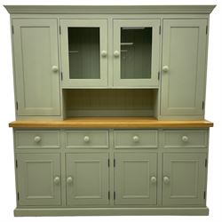 Painted kitchen dresser, projecting moulded cornice over central glazed display doors and flanking panelled cupboard doors, polished oak rectangular top over four drawers and four cupboards, on moulded plinth base, in laurel green paint finish 