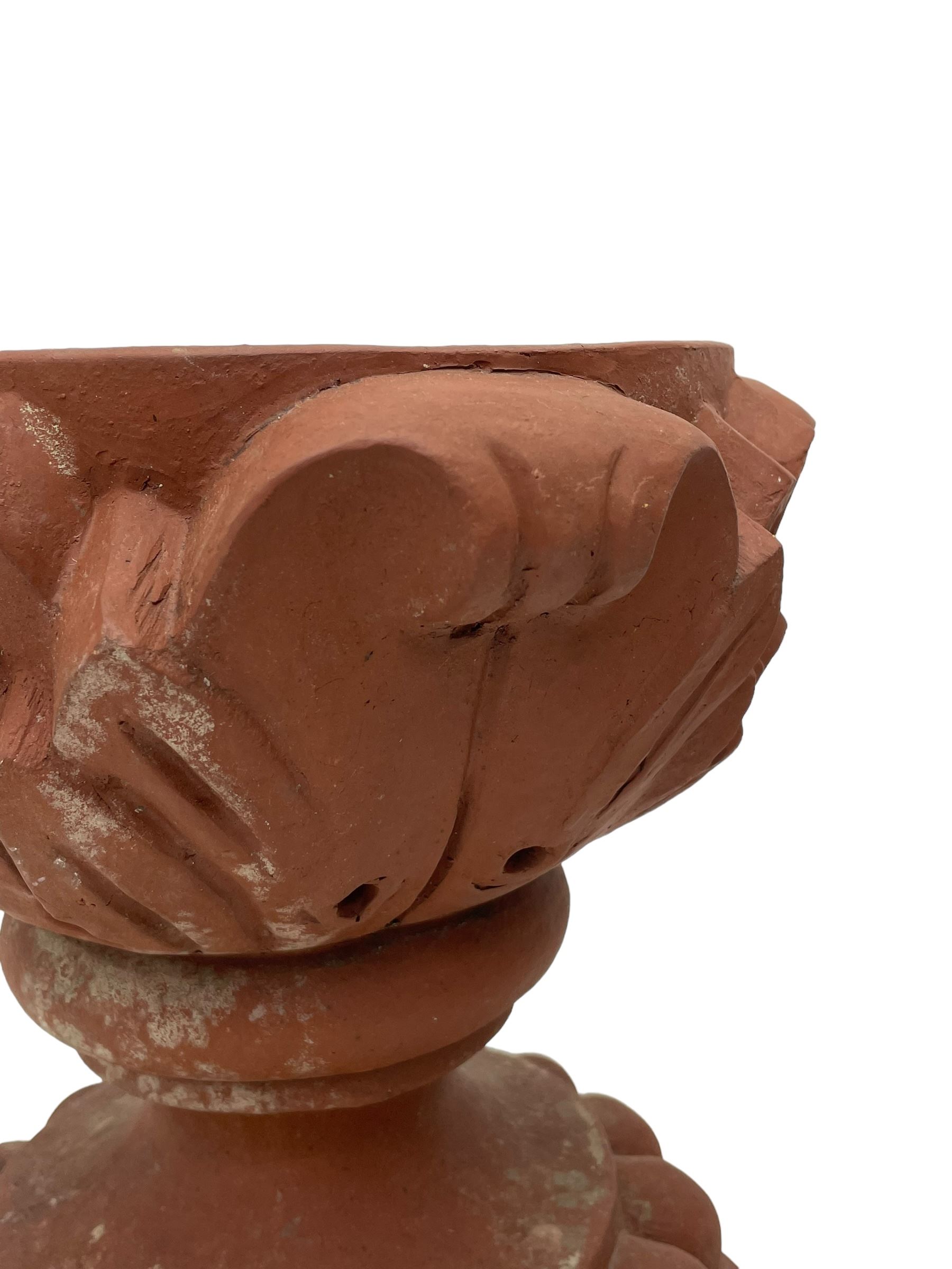 Pair of late 19th to early 20th century red terracotta garden urn planters, the shallow bowls moulded with curled acanthus leaf decoration, on circular foot with globular beaded moulding, octagonal base