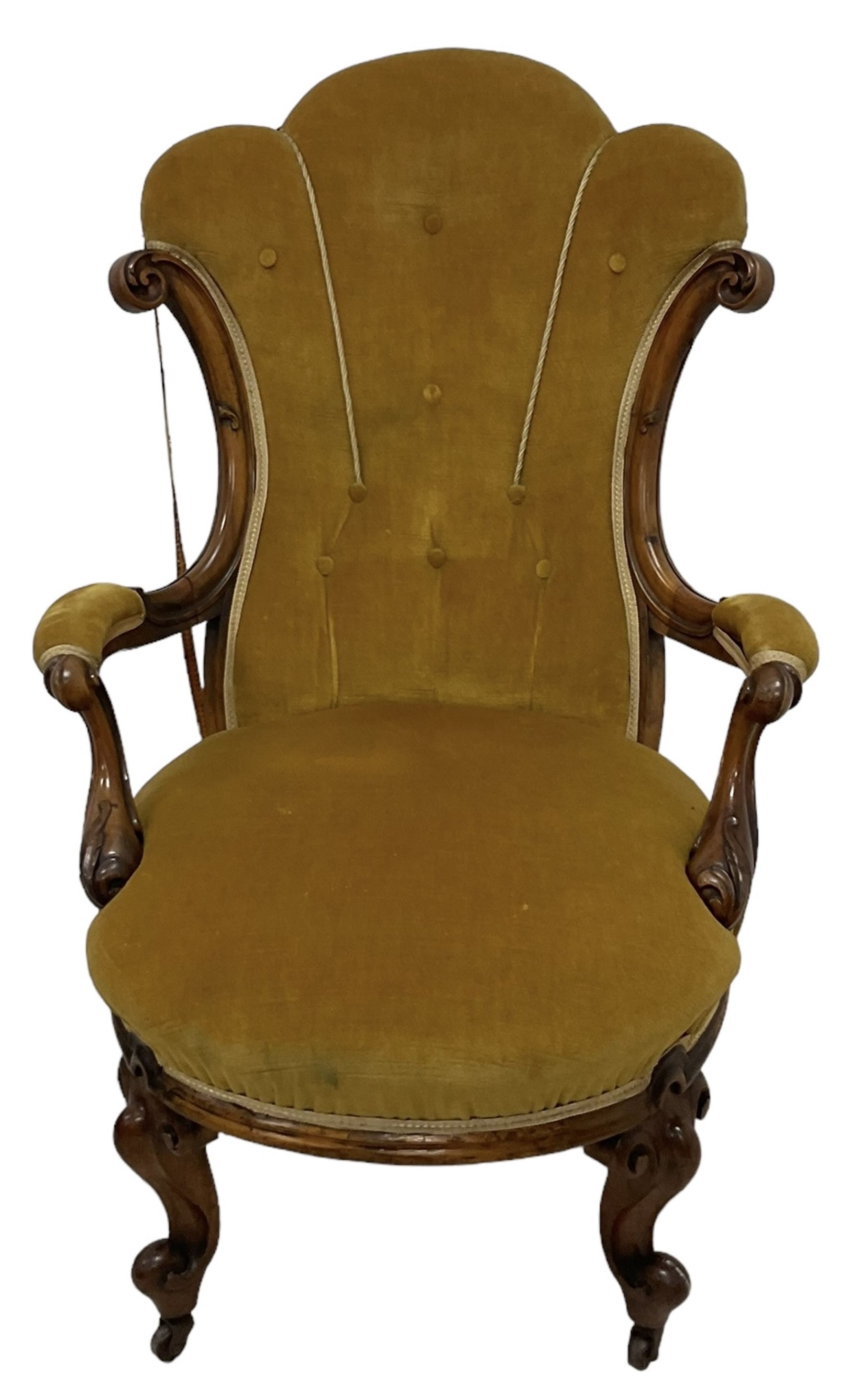 19th century walnut framed open armchair, scallop shaped back with c-scroll uprights, upholstered in yellow buttoned velvet fabric with sprung seat, arm terminals carved with acanthus leaves, raised on scrolling cabriole supports with castors