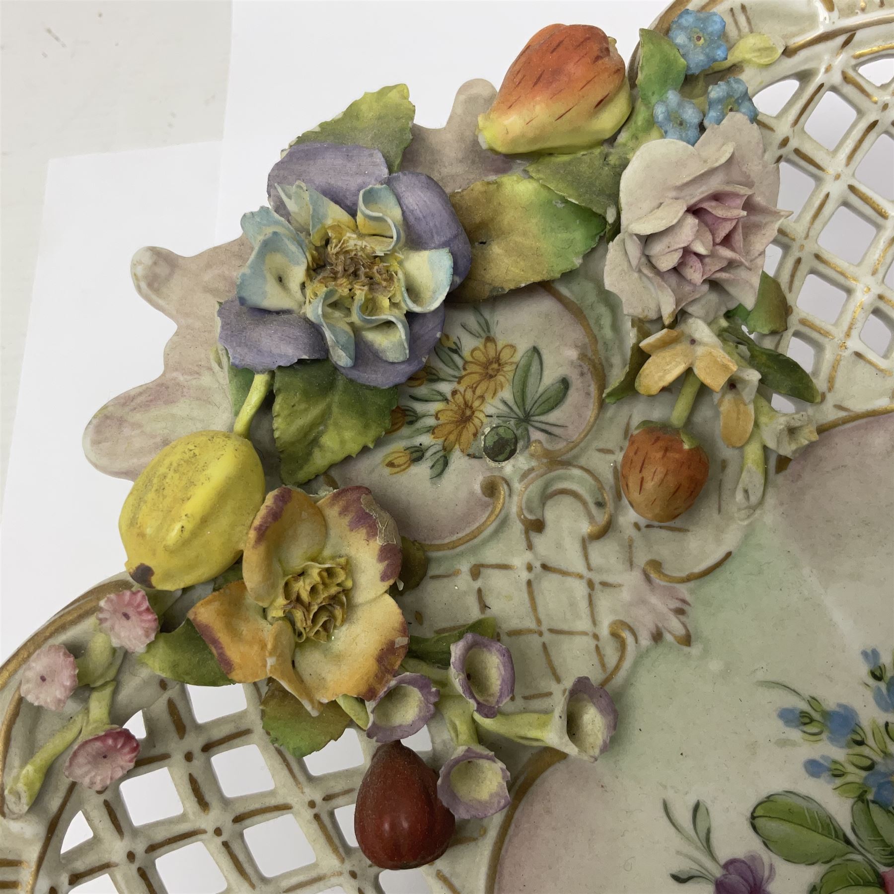 19th Meissen style centrepiece, with pierced lattice work sides and decorated in relief with fruit and floral sprigs, upon four scrolled feet, with spurious mark beneath H9cm D31cm