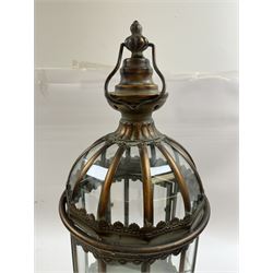 Pair of patinated brushed brass lanterns, of domed hexagonal form, with pierced gallery and swing handle, H63cm 


