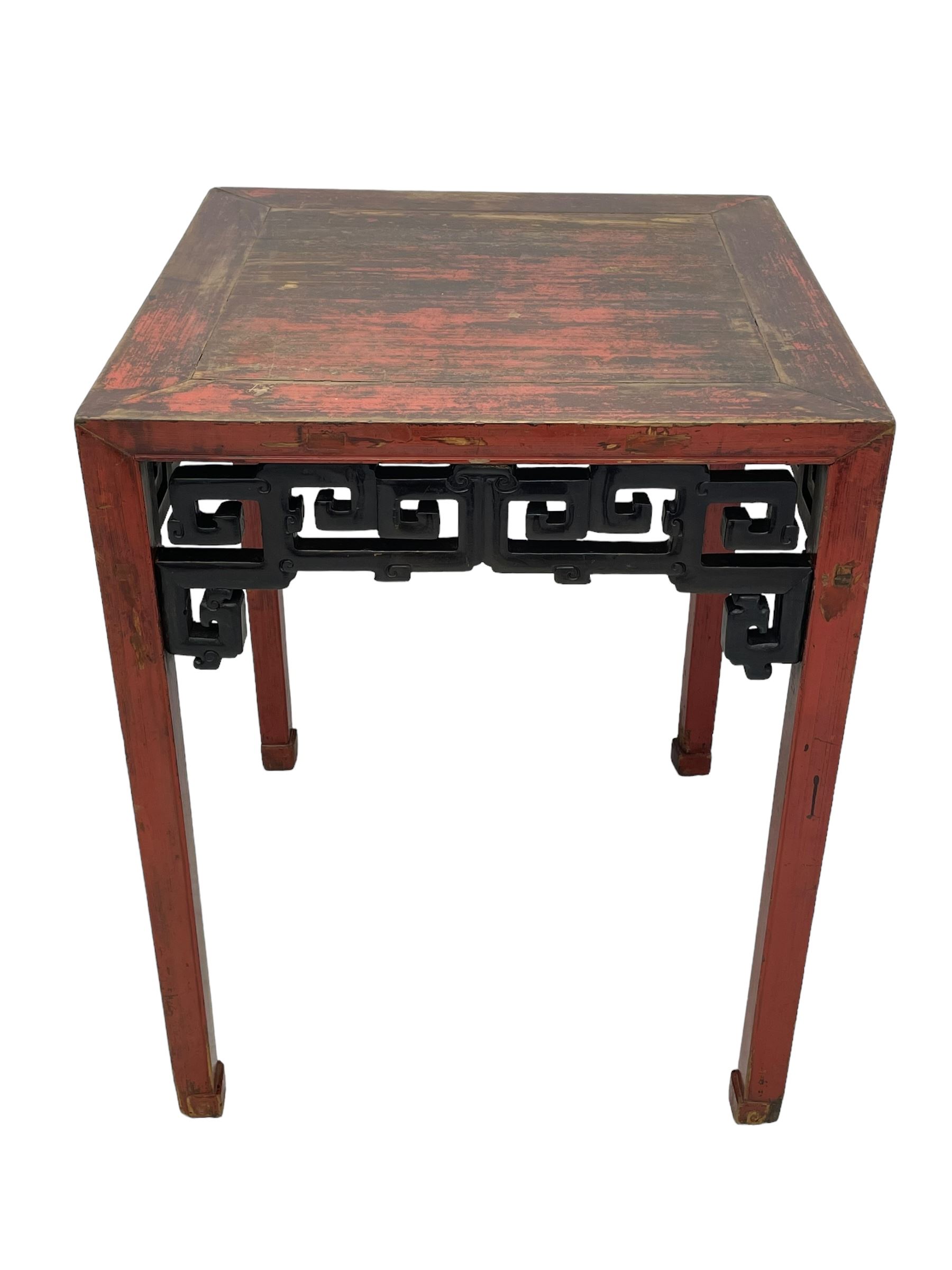 Late 19th century Chinese Qing dynasty red and black lacquered wood tall tea table, Shanxi region, square top over geometric scroll fretwork panels, on square supports with hoof feet 